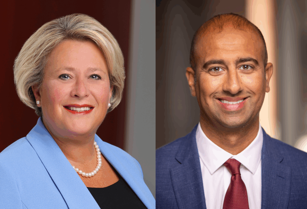 A woman with short blonde hair in a light blue blazer and pearl necklace, and a man with short dark hair in a blue suit, white shirt, and red tie, both smiling in professional portraits.